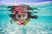 French Polynesia, Moorea, Woman free diving in turquoise ocean.