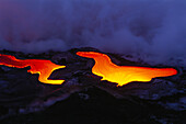 Hawaii, Big Island, Hawaii Volcanoes National Park, Pahoehoe glowing lava flow, river like smoke in background.