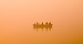 'The Ganges, Varanasi, India;Man Rowing Family In A Canoe On The River'