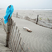 A turquoise bikini on a wooden fence post in the dunes on a deserted coast beach., Ocean Park,  Washington, USA