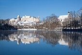 St Mang's abbey and Hohes Schloss reflecting in the Lech river, Fuessen, Allgaeu, Bavaria, Germany