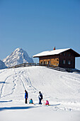 People sledging at Eckbauer, Alpspitze in the background, Garmisch-Partenkirchen, Bavaria, Germany