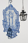 Shadow of lamp on the wall of a church with Azulejo tile mural at Jardim de Julio de Catilho in Alfama district, Lisbon, Lisboa, Portugal