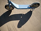 A light blue scooter casts a shadow in intense sunlight in Santa Barbara, California, United States