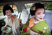 Fukuyu,geisha and Fukukimi,´maiko´ geisha apprenticein taxi going to work They say goodbye at Oka san  Geisha´s distric of Miyagawacho Kyoto  Kansai, Japan