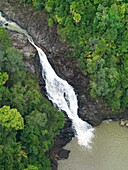 An aerial image of a waterfall cutting through the dense jungle in Johor, Malaysia