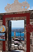Looking down through doorway at romantic restaurant and the sea with statue in Santorini Greece in Greek Islands