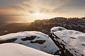 Sunset above the Saxon Switzerland national park with wide view above the Schmilkaer Kessel in winter, Saxony, Germany