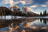 Picturesque sunset above the mirror-like Lago de Antorno with the numerous peaks of Cadini Misurina in the background, South Tyrol, Italy