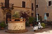 Fountain and motor scooter on Piazza di Spagna, Pienza, Val d'Orcia, Orcia valley, UNESCO World Heritage Site, province of Siena, Tuscany, Italy, Europe