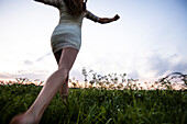 Young woman running over a meadow, Upper Bavaria, Germany