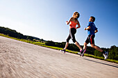 Two people jogging along a road, Upper Bavaria, Germany