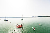 Junge Leute auf einer Schwimminsel im Starnberger See, Bayern, Deutschland