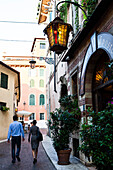 Couple passing a restaurant, Verona, Veneto, Italy