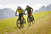 Two mountain bikers off roading, Eckbauer, Garmisch-Partenkirchen, Bavaria, Germany