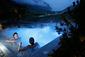 Hotel guests bathing in an outdoor saltwater bath, Tannheim, Tannheim Valley, Tyrol, Austria