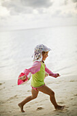Girl running along beach, Biyadhoo Island, South Male Atoll, Maldive Islands