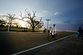Cyclists passing a street, Arugam Bay, Ampara District, Sri Lanka