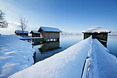 Verschneite Bootshäuser am Kochelsee, Oberbayern, Deutschland