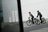 Couple riding e-bikes, Munich, Bavaria, Germany