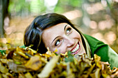 Young woman lying on autumn leaves, Styria, Austria