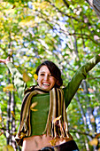 Young woman throwing autumn leaves in the air, Styria, Austria