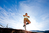 Man wearing traditional clohtes practicing yoga, Styria, Austria