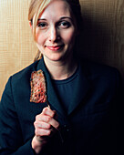 USA, California, Los Angeles, portrait of a young waitress holding a slice of steak on a fork at CUT Restaurant.