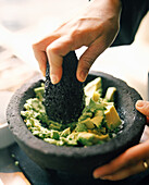 MEXICO, Mexico City, person making guacamole in molcajete, close-up at the W Hotel.