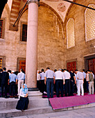 TURKEY, Istanbul, rear view of people praying at Sultan Ahmed mosque