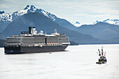 ALASKA, Sitka, a fishing boat passes by a cruise ship that is anchored for the night, Crescent Bay, Sitka Sound