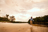 BRAZIL, Agua Boa, fly fisherman casting on a tributary of the Amazon River, Agua Boa River and resort