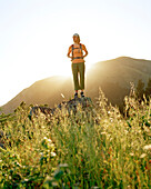 USA, California, young woman standing on rock in front of Mount Tamalpais