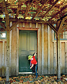 USA, California, girl closing a door in the Fall