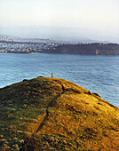 USA, California, woman hiking in the Marin Headlands with San Francisco in the distance