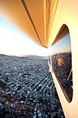 USA, California, San Francisco, woman looking out the window of the Airship Ventures Zepplin, San Fracisco looking north