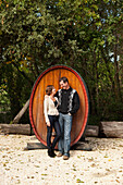 USA, California, Sonoma, travelers on a wine tour stand in front of a large wine barrel at the Buena Vista Carneros winery