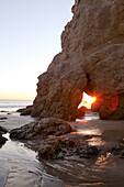 USA, California, Malibu, the sun sets behind a rock formation at El Matador beach