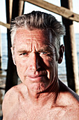 USA, California, Malibu, portrait of the former Malibu mayor and the owner of Zuma Jay surf shop Jefferson Wagner by the Malibu Pier, Surfrider Beach