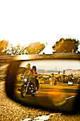 USA, California, Malibu, a couple on a motorcycle cruises along the Pacific Coast Highway at the end of the day