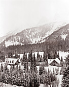 CANADA, Island Lake Lodge and trees in snow covered landscape, elevated view (B&W)