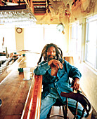 CAYMAN ISLANDS, Caribbean, portrait of man with dreadlocks at a bar, Grand Cayman