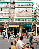 CHINA, Hangzhou, people riding bicycles in commercial district