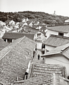 CHINA, elevated view of farmer walking outside houses, Putuoshan (B&W)