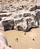 ERITREA, Foro, Bedouin boys swim and cool off in a muddy desert watering hole