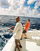 USA, Florida, men catching fish on the back of a boat, Islamorada
