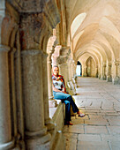 FRANCE, Burgundy, young woman sitting in Abbaye De Fontenay, Marmagne