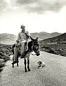 GREECE, Patmos Island, portrait of a shepard Stephanos riding his donkey Alekos from the sea to his animals inland (B&W)
