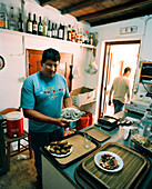 GREECE, Patmos, Diakofti, Dodecanese Island, Kostas Grillakis prepare food at his family taverna, Diakofti Taverna