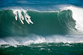 USA, Hawaii, the North Shore Oahu, surfers dropping in on a wave at Waimea bay